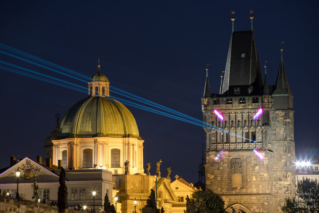 Den světla - Karlův most s laserovou instalací - Staroměstská mostecká věž a Kostel sv. Františka z Assisi